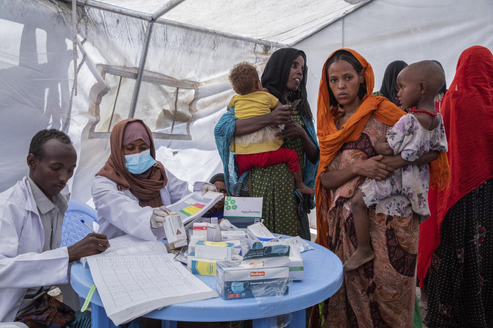 In this photo released by UNICEF, a mobile health and nutrition team attends to displaced mothers and their children at the Guyah site for internally-displaced people in the Afar region of Ethiopia Tuesday, May 10, 2022.. According to UNICEF, the Afar region is facing multiple humanitarian emergencies and mass displacement due to drought and conflict, which has resulted in devastating food insecurity. (Zerihun Sewunet/UNICEF via AP)