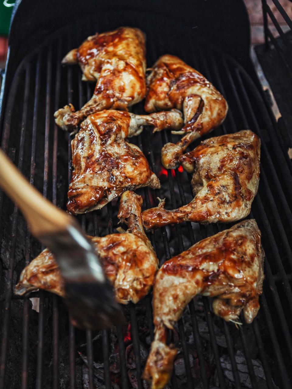 Jerk chicken is traditionally cooked over fire, but similar flavours can be achieved on a grill (Getty)