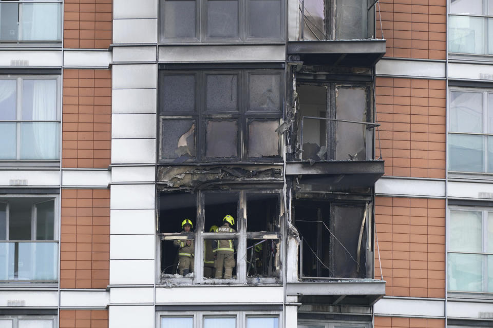 Firefighters inspect damage to a 19-storey tower block in New Providence Wharf in London, Friday, May 7, 2021. Firefighters have tacked a blaze in a London apartment tower that has cladding similar to that used on a building where 72 people died in 2017. London Fire Brigade said about 125 firefighters tackled a fire on Friday that spread to three floors of a 19-story building in the city’s docklands. (Yui Mok/PA via AP)