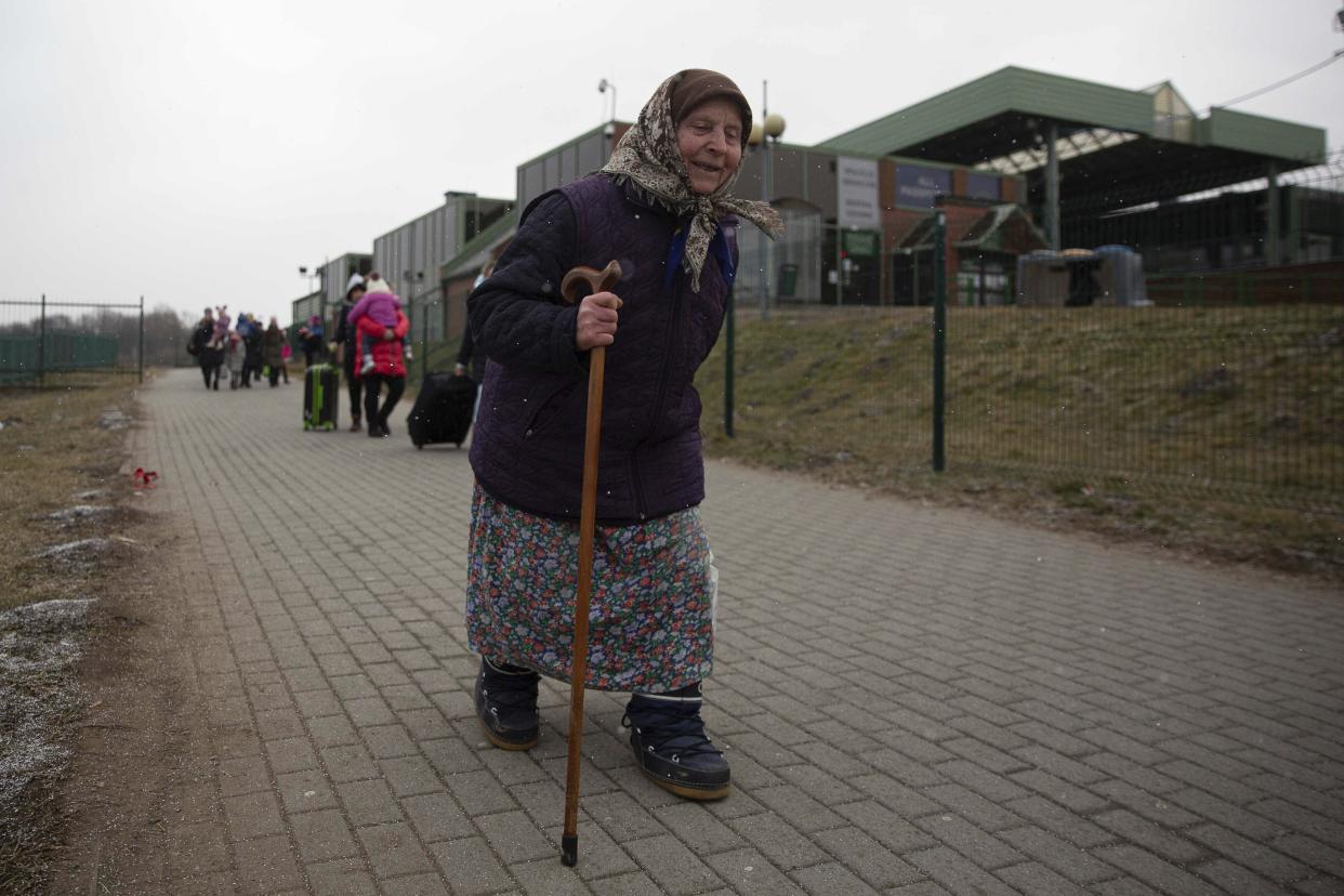 An old woman holds on to a walking stick as refugees, mostly women with children, arrive at the border crossing in Medyka, Poland, Saturday, March 5, 2022, after fleeing Russian invasion in Ukraine. (AP Photo/Visar Kryeziu)