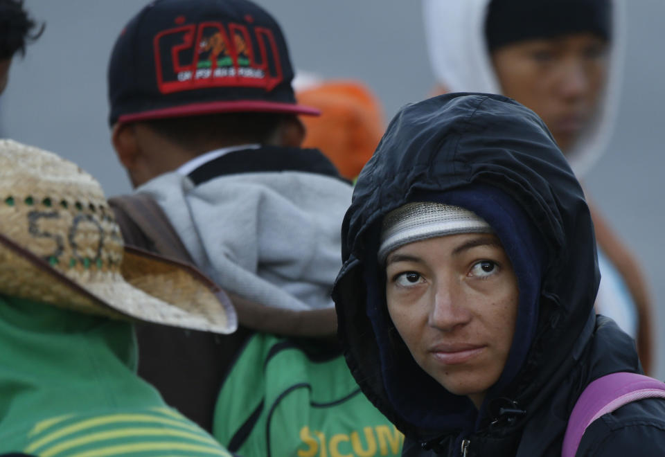 Central American migrants who are part of a caravan hoping to reach the U.S. border leave Guadalajara, Mexico, early Tuesday, Nov. 13, 2018. While they previously suffered from the heat on their journey through Honduras, Guatemala and southern Mexico, they now trek along highways wrapped in blankets to fend off the morning chill. (AP Photo/Marco Ugarte)