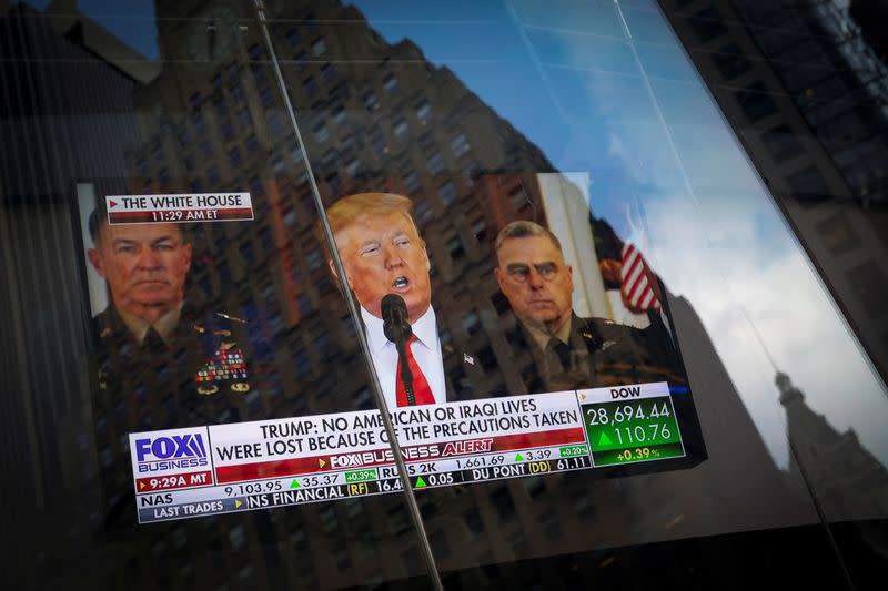 U.S. President Donald Trump is seen on a screen reflected in a window as he delivers a statement from the White House in New York