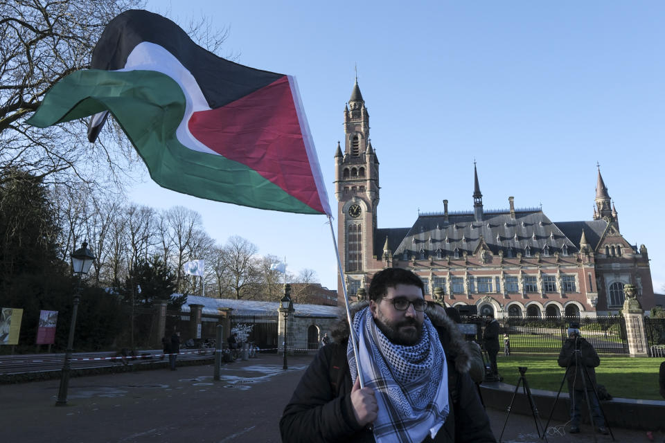 Un manifestante alza una bandera palestina frente al Palacio de la Paz, sede de la Corte Internacional de Justicia, el viernes 26 de abril de 2024, en La Haya, Holanda. (AP Foto/Patrick Post)
