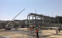 Workers are seen at the damaged site of Saudi Aramco oil facility in Khurais