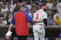 Philadelphia Phillies' Bryce Harper, right, reacts towards San Diego Padres' Blake Snell after being hit by a pitch from Snell, as he walks off the field with a trainer during the fourth inning of a baseball game Saturday, June 25, 2022, in San Diego. (AP Photo/Derrick Tuskan)