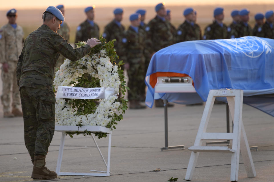 UNIFIL commander Maj. Gen. Aroldo Lázaro Sáenz of Spain, adjusts a wreath in front the coffin draped by the United Nations flag of the Irish U.N Peacekeeper soldier Pvt. Seán Rooney who was killed during a confrontation with residents near the southern town of Al-Aqbiya on Wednesday night, during his memorial procession at the Lebanese army airbase, at Beirut airport, Sunday, Dec. 18, 2022. (AP Photo/Hussein Malla)