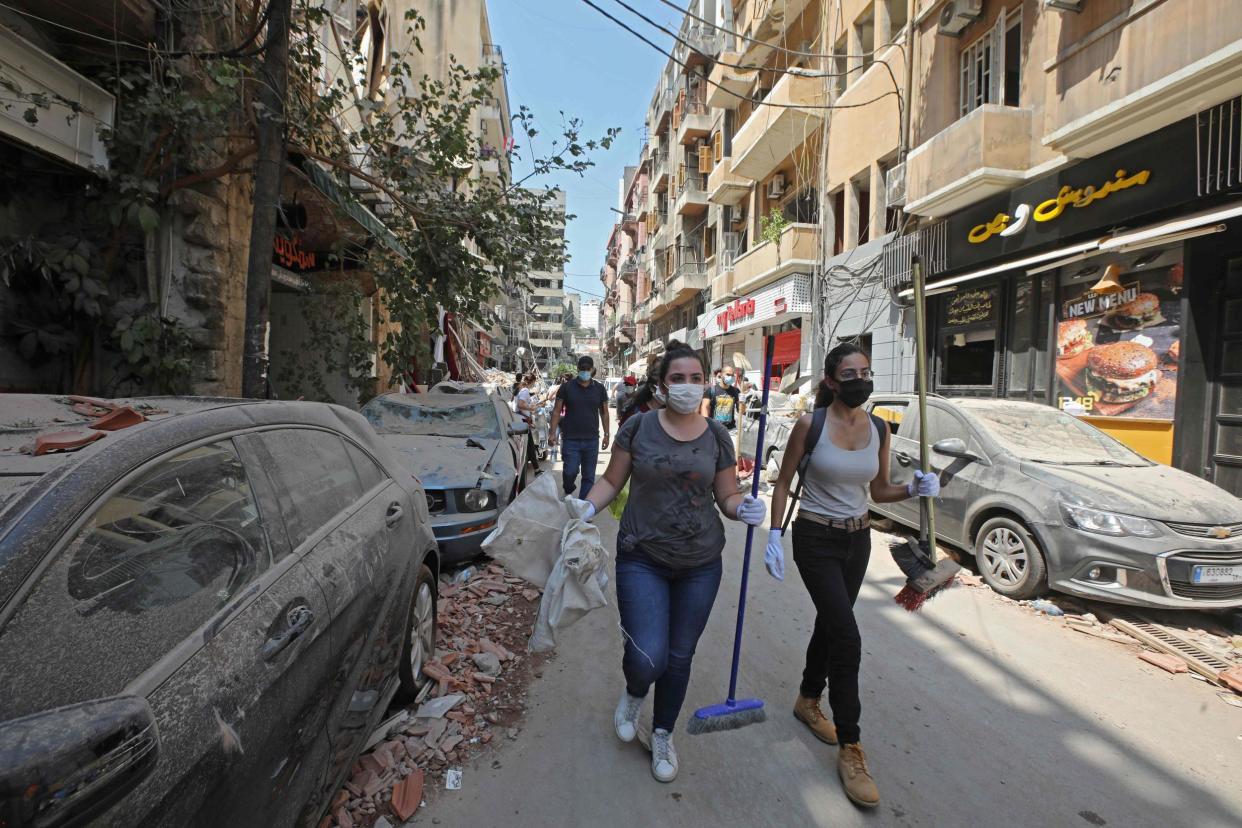 Volunteers carrying brooms and other equipment arrive on Gouraud street in the Gemmayze neighbourhood of Beirut, to clear debris on August 6, 2020, two days after a massive explosion shook the Lebanese capital: ANWAR AMRO / AFP