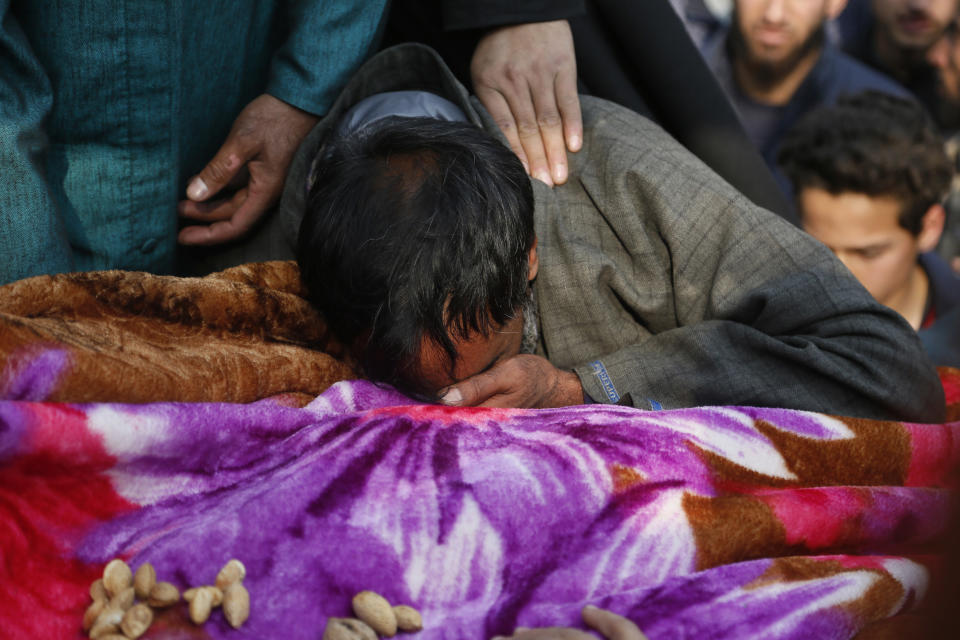 An unidentified Kashmiri Muslim man weeps near the body of rebel Bashrat Ahmad during his funeral at Shopian, south of Srinagar, Indian controlled Kashmir, Tuesday, Nov. 20, 2018. Four rebels and an Indian army commando were killed in fighting in disputed Kashmir on Tuesday, triggering anti-India protests and clashes in the restive region. (AP Photo/Mukhtar Khan)