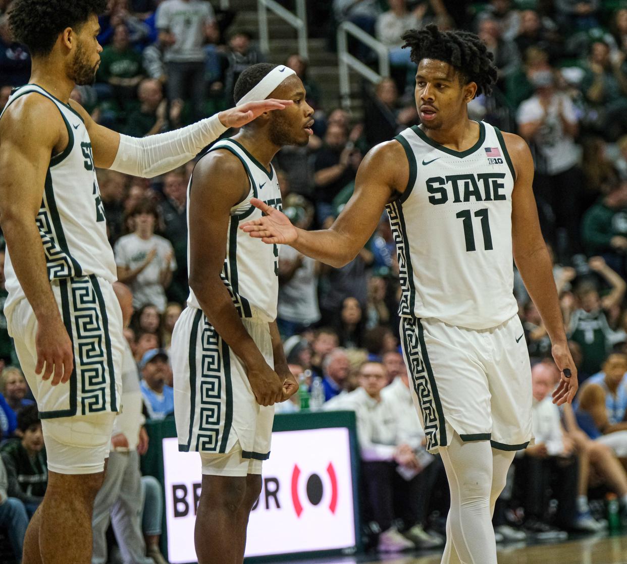 Michigan State players A.J. Hoggard (11), right, Tre Holloman (5), center, and Malik Hall (25) congratulate each other after a good play against Indiana State Saturday, Dec. 30, 2023. The Spartans won 87-75.