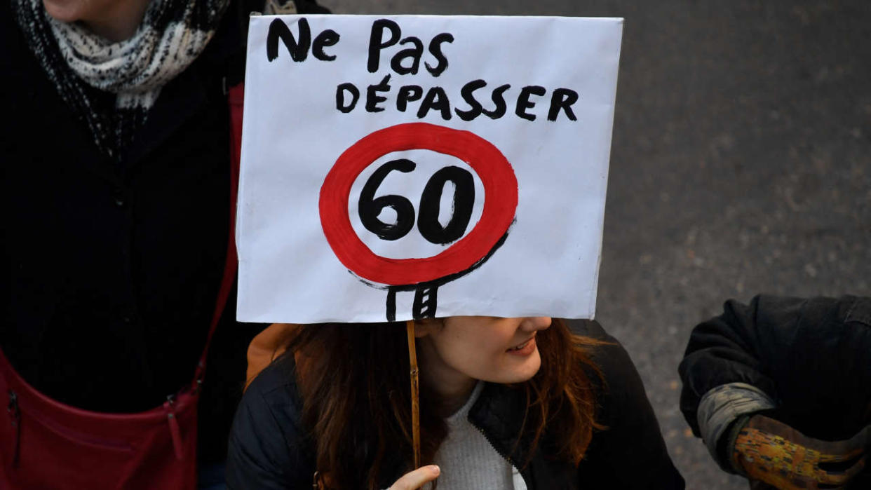 A protester holds a placard reading 