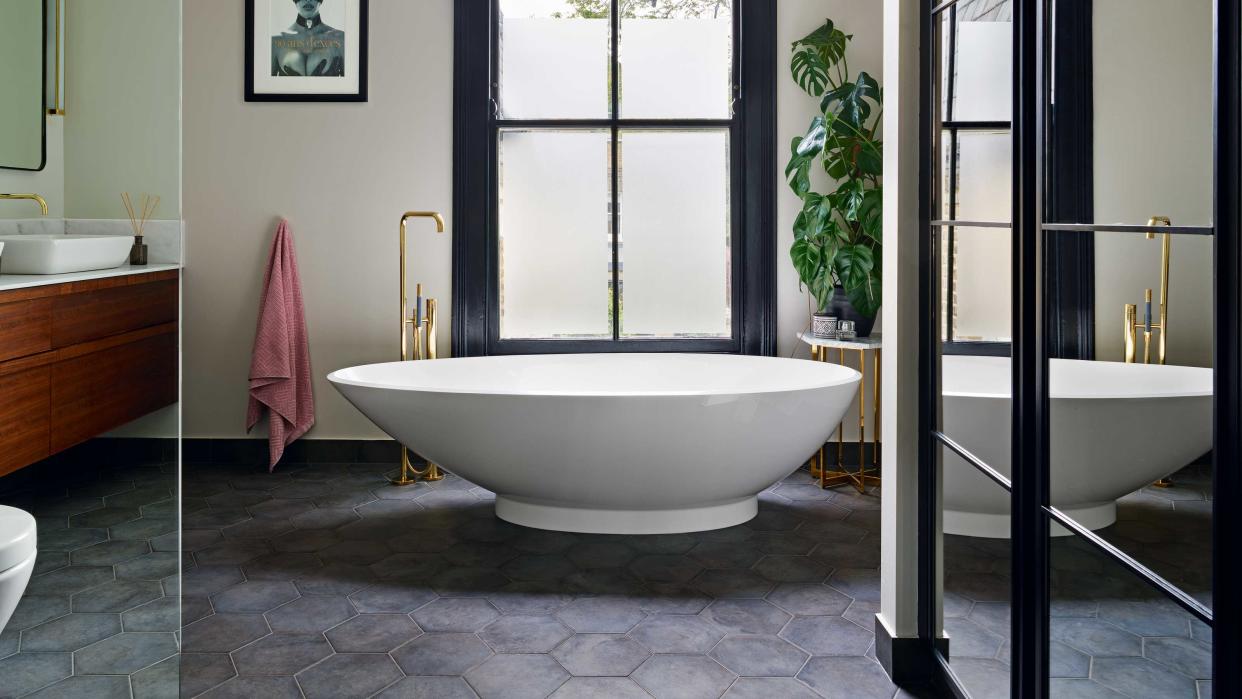  bathroom with freestanding tub and cabinetry 