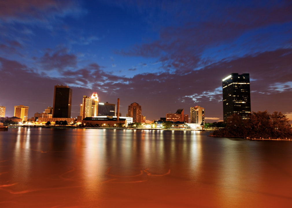 A body of water at night with skyline in the background.