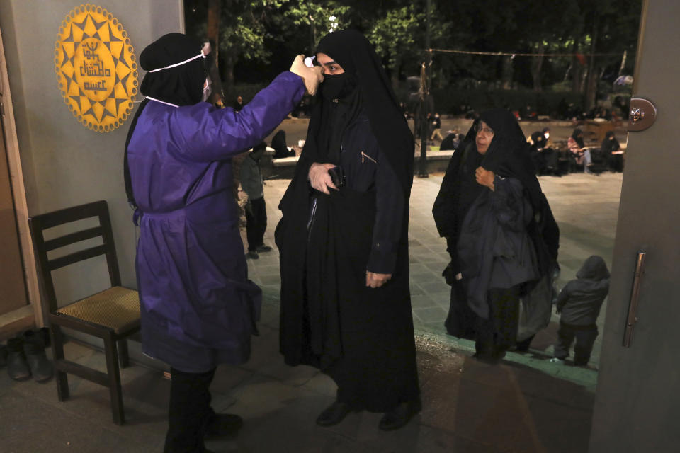 A worshipper has her temperature checked to help prevent the spread of the coronavirus as she enters the Tehran University mosque to pray on Laylat al-Qadr, or the night of destiny, during holy fasting month of Ramadan, in Tehran, Iran, Tuesday, May 12, 2020. On Tuesday authorities allowed mosques temporarily reopen for limited hours up to two hours strictly observing health and social procedures to prevent spreading the disease, in the predominantly Shiite country for three continuous nights from Tuesday which people believe the Laylat al-Qadr night happens either on 19th, 21st or 23rd of the holy month of Ramadan. Laylat al-Qadr is the night when Muslims believe the Quran was first revealed to prophet Muhammad. (AP Photo/Vahid Salemi)