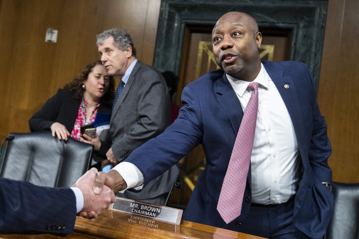 Senator Tim Scott shakes hands with someone at a Senate committee hearing.