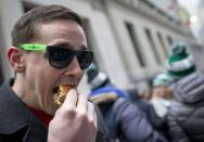 Robby Keesb eats a Shake Shack burger in front of New York Stock Exchange as part of the company's IPO celebration January 30, 2015. REUTERS/Brendan McDermid