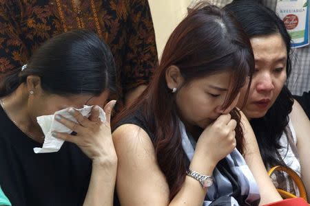 Family members of Grayson Herbert Linaksita, a passenger of AirAsia Flight QZ8501, cry before receiving his remains at Bhayankara Hospital in Surabaya January 2, 2015. REUTERS/Sigit Pamungkas