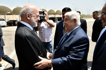Iraq's Foreign Minister Ibrahim al-Jaafari (L) shakes hands with his Syrian counterpart Walid al-Muallem at Baghdad airport August 25, 2016. Iraqi Foreign Minister Office/Handout via REUTERS