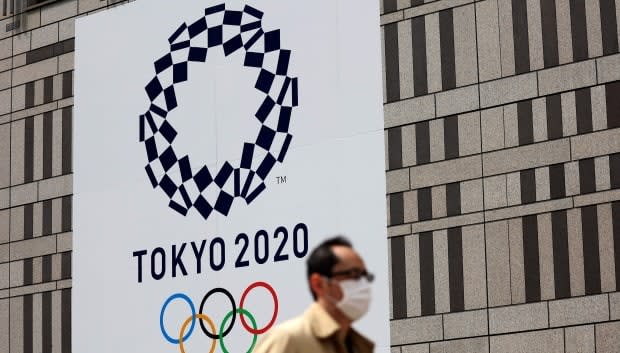 A pedestrian walks past an official Tokyo 2020 Olympic Games banner on the Tokyo metropolitan government building in April.