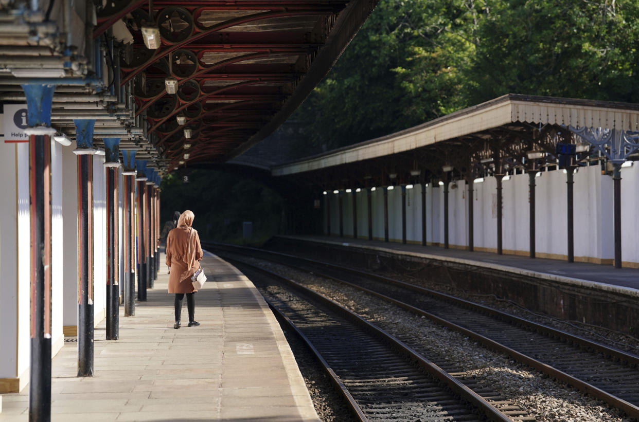 A passenger waits at Great Malvern train station as members of the Rail, Maritime and Transport union begin their nationwide strike, in Worcester, England, Tuesday June 21, 2022. Tens of thousands of railway workers walked off the job in Britain on Tuesday, bringing services grinding to a halt in the country’s biggest transit strike in three decades. (David Davies/PA via AP)