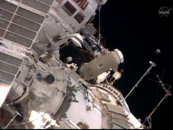 Cosmonaut Oleg Artemyev looks on after he released a small Peruvian satellite into space during a spacewalk outside the International Space Station on Aug. 18, 2014.