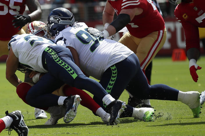 Seattle Seahawks linebacker Cody Barton, left, and defensive tackle Bryan Mone tackle San Francisco 49ers quarterback Trey Lance during the first half of an NFL football game in Santa Clara, Calif., Sunday, Sept. 18, 2022. Lance left the game after this play. (AP Photo/Josie Lepe)