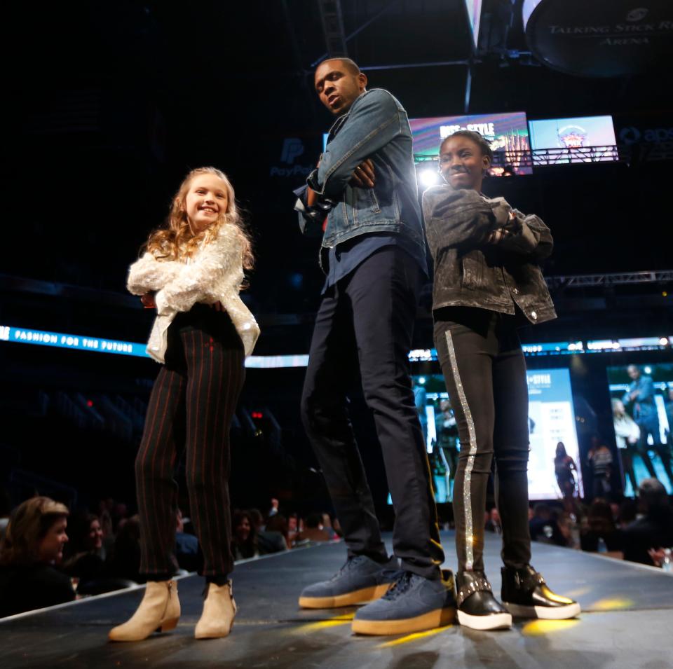 Suns' GM James Jones poses for pictures with Trinity Henry and Leah Johnson (L) during "Rise in Style," a charity fashion show at Talking Stick Resort Arena in Phoenix, Ariz. on January 11, 2020. 