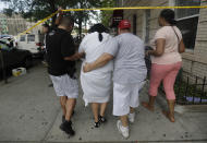 <p>A woman is escorted by officers in plainclothes near the Bronx Lebanon Hospital Center after reports of a shooting, Friday, June 30, 2017, in New York. (AP Photo/Julio Cortez) </p>