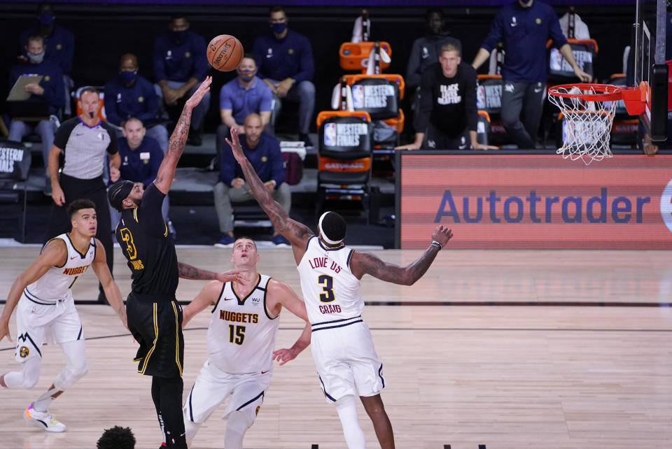 Los Angeles Lakers' Anthony Davis shoots over Denver Nuggets' Nikola Jokic (15) and Torrey Craig, right, during the second half of an NBA conference final playoff basketball game Sunday, Sept. 20, 2020, in Lake Buena Vista, Fla. The Lakers won 105-103. (AP Photo/Mark J. Terrill)