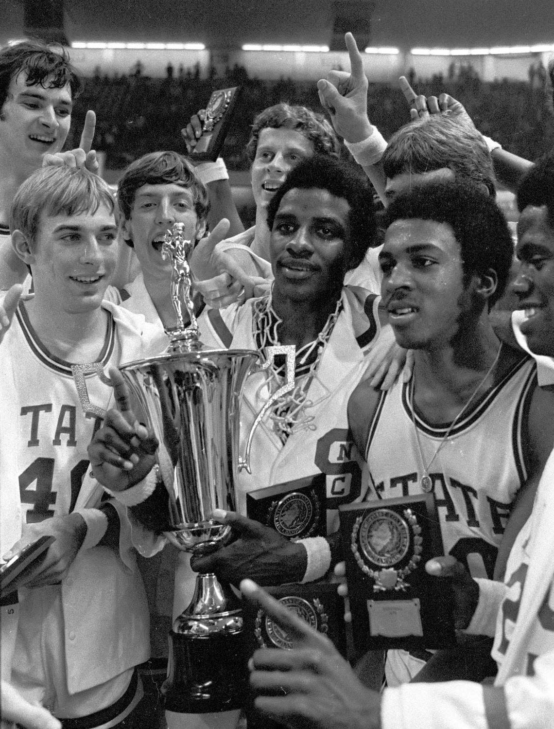 NC State players celebrate with the ACC Tournament championship trophy after their win in 1974.