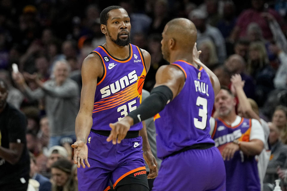 Phoenix Suns forward Kevin Durant (35) celebrates a basket with Chris Paul during the first half of an NBA basketball game against the Denver Nuggets, Friday, March 31, 2023, in Phoenix. (AP Photo/Matt York)