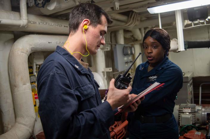 Gas Turbine Systems Technician (Electrical) 3rd Class Chaise Lunsford, left, from Mansfield, and Gas Turbine Systems Technician (Mechanical) 3rd Class Leandria Ray, from Valsosta, Georgia, review an emergency operational casualty control manual during an in-port emergency team drill aboard the Arleigh Burke-class guided-missile destroyer USS Jason Dunham (DDG 109) in the Atlantic Ocean on June 11.