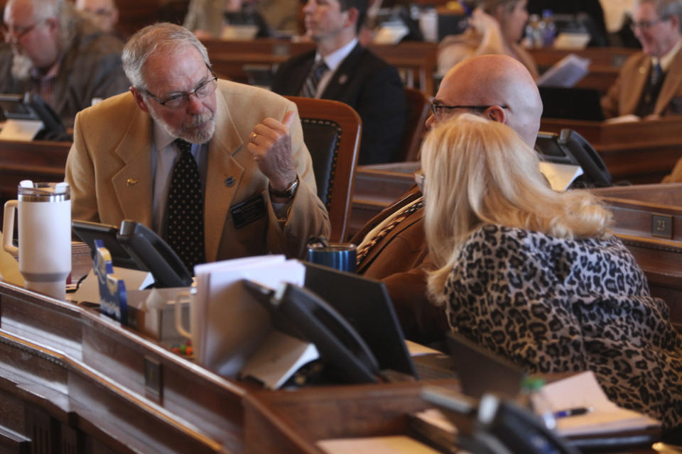 Kansas state Rep. Will Carpenter, left, R-Winfield, confers with two House Appropriations Committee members, Rep. Stephen Owens, center, R-Hesston, and Susan Concannon, R-Beloit, during a House session, Wednesday, March 27, 2024, at the Statehouse in Topeka, Kan. Carpenter has been pushing to increase the state's spending on in-home and community services for disabled to shrink waiting lists for those services. (AP Photo/John Hanna)