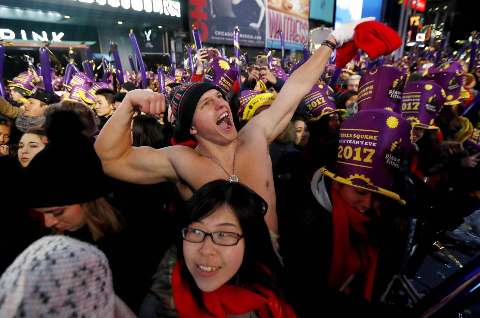 FILE - In this Dec. 31, 2016 file photo, Andrew Dickens, 21, of Toledo, Ohio, stands with other revelers during the New Year's Eve celebration in New York's Times Square. Year after year, people watching New York City's New Year's Eve celebration are told by city dignitaries and TV personalities that they are watching a million people gathered in Times Square. The AP asks experts whether it is actually possible to fit that many people into the viewing areas. (AP Photo/Julio Cortez, File)