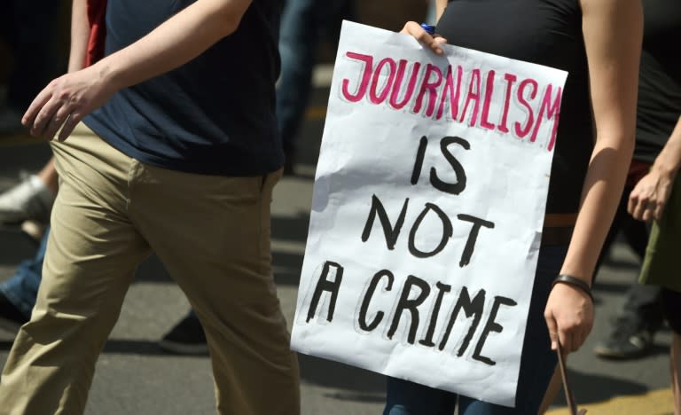 A protester holds a poster reading, "Journalism in not a crime" during a demonstration on August 1, 2015 in Berlin, in reaction to a treason investigation against two writers of the news blog Netzpolitik