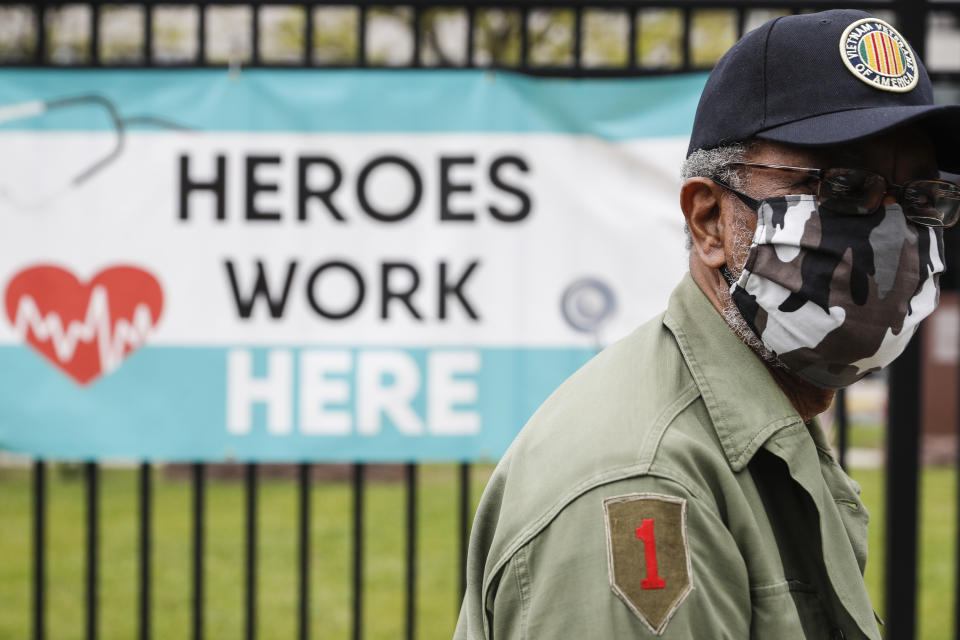 A motorcade of veterans stops outside the VA Medical Center as wreaths are laid beside memorial stones on the premises, Monday, May 25, 2020, in the Brooklyn borough of New York. (AP Photo/John Minchillo)