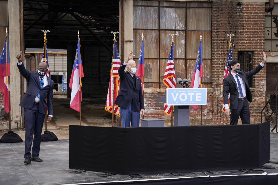 Democratic Senate candidates Rev. Raphael Warnock (L) and Jon Ossoff (R) join U.S. President-elect Joe Biden at a drive-in rally at Pullman Yard on December 15, 2020 in Atlanta, Georgia. (Photo by Drew Angerer/Getty Images)