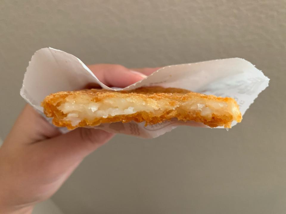 hand holding jack in the box hash brown in package
