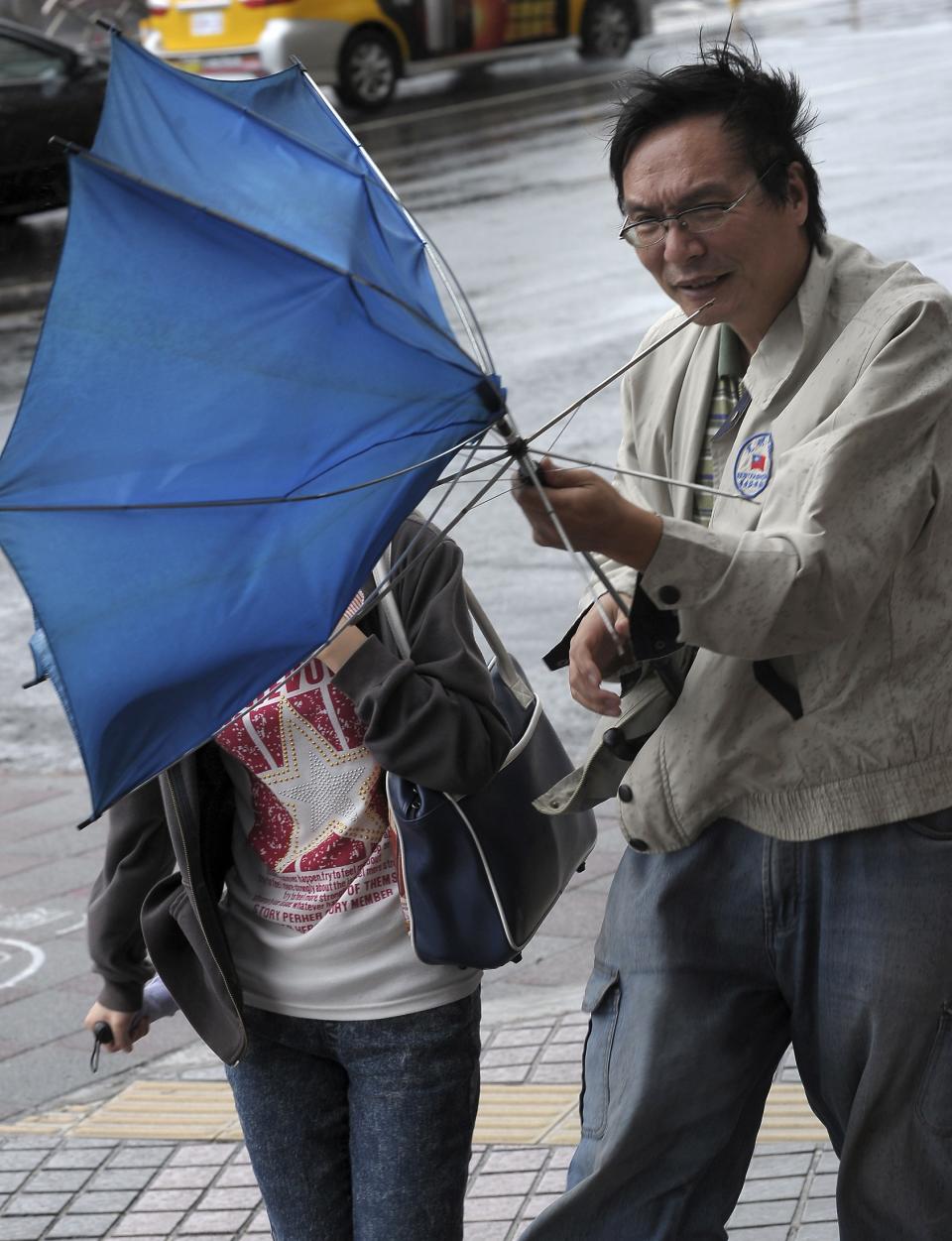 A man holds an inside-out umbrella broken due to strong winds as Typhoon Usagi approaches Taiwan, in Taipei September 21, 2013. Usagi, which has been labelled a super typhoon, made landfall on Itbayat, the Philippine island closest to Taiwan, toppling communication and power lines, uprooting trees, causing landslides and flooding rice and garlic farms. REUTERS/Stringer (TAIWAN - Tags: ENVIRONMENT DISASTER) TAIWAN OUT. NO COMMERCIAL OR EDITORIAL SALES IN TAIWAN