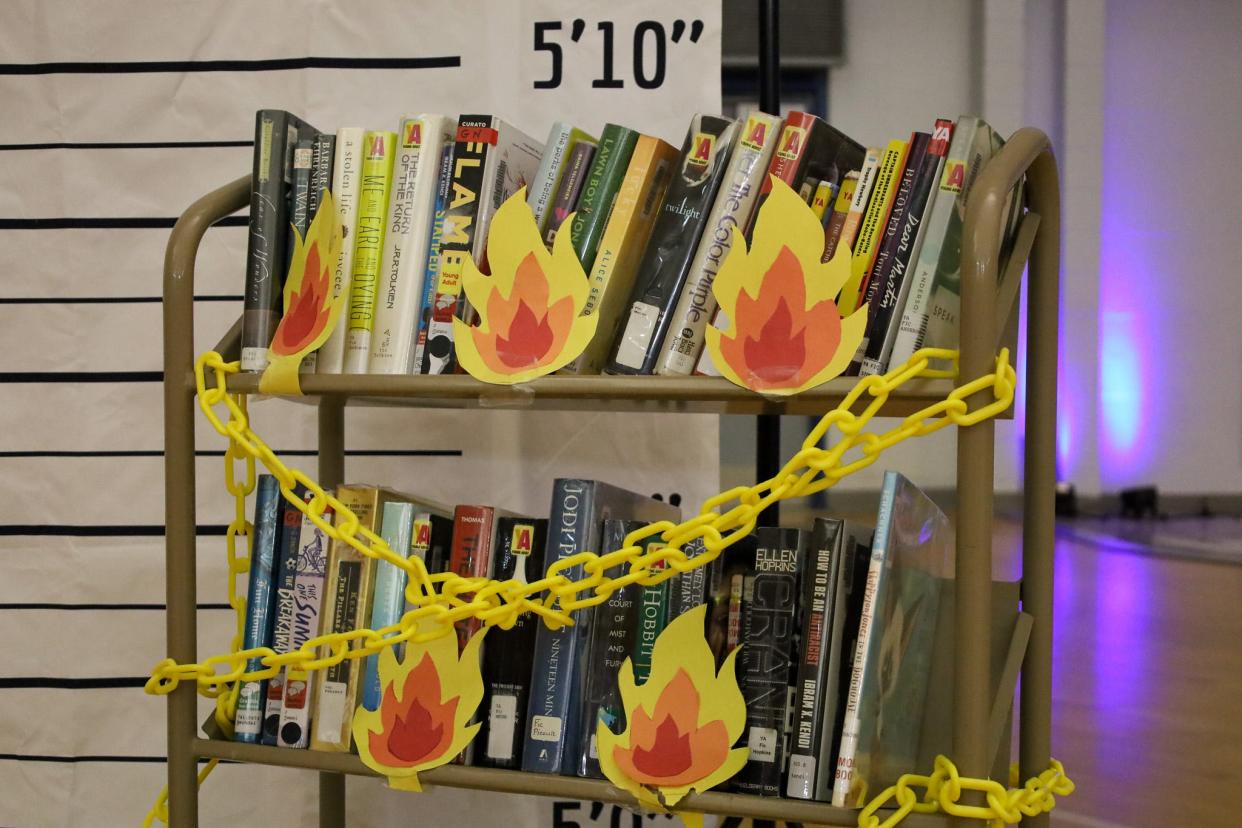 A photo booth at Library Con 2023 in Monaca, Pa., allowed visitors to pose with books that have been removed from libraries and schools across the United States.