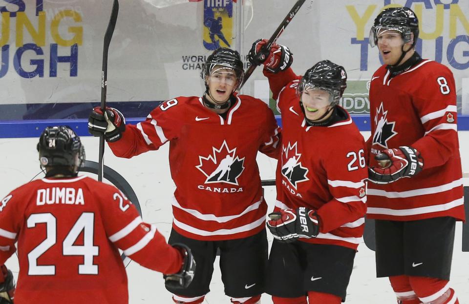 Canada's Curtis Lazar (26) celebrates his goal against Switzerland with teammates Griffin Reinhart (8), Nic Petan and Matt Dumba (L) during the third period of their IIHF World Junior Championship ice hockey game in Malmo, Sweden, January 2, 2014. REUTERS/Alexander Demianchuk (SWEDEN - Tags: SPORT ICE HOCKEY)