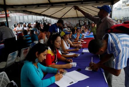 Miles de venezolanos salían el domingo a votar en un plebiscito contra el Gobierno de Nicolás Maduro, que esperan sea masivo para poder exigirle al mandatario socialista que convoque elecciones presidenciales antes de que culmine su mandato, a principios del 2019. En la imagen, venezolanos votan en Caracas, el 16 de julio de 2017. REUTERS/Carlos Garcia Rawlins