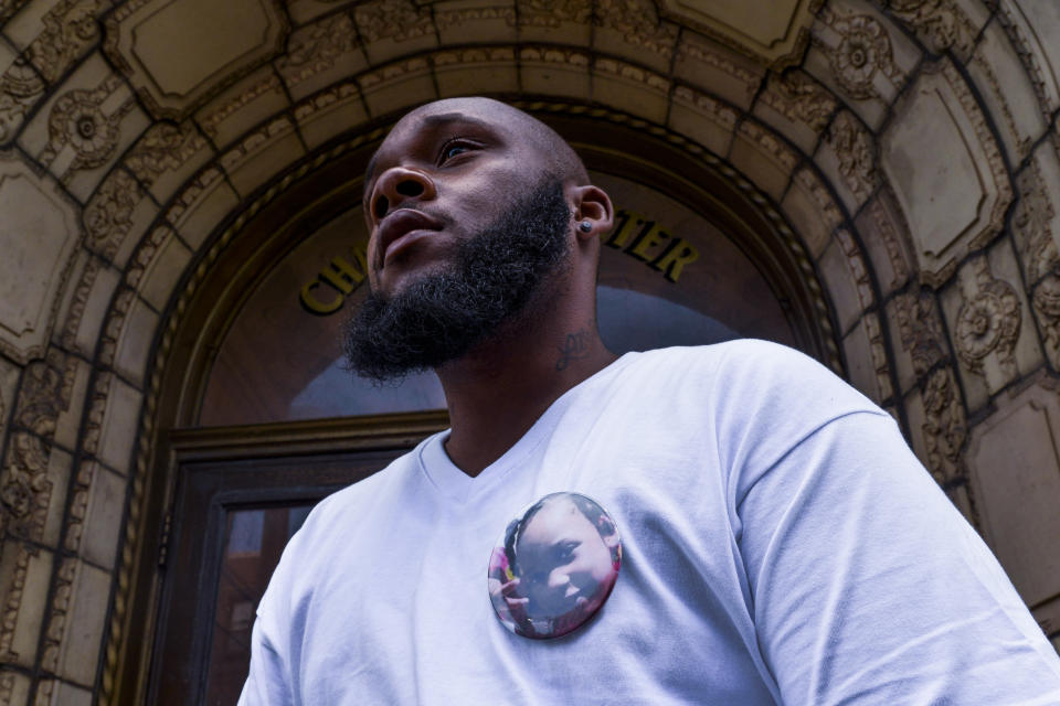 Nathan Wallace stands outside of his home wearing a button showing his daughter, Natalia Wallace, on Monday, Aug. 3, 2020, in Chicago. Natalia, 7, was killed on the west side of Chicago on July 4, 2020. (AP Photo/Matt Marton)