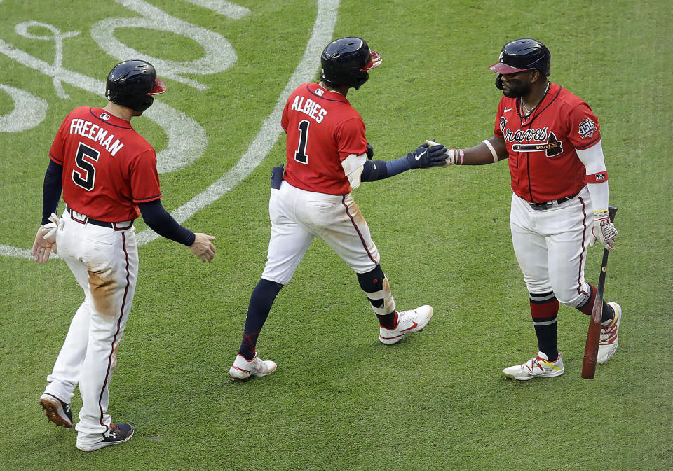 Atlanta Braves' Ozzie Albies (1) is congratulated by Abraham Almonte, right, after hitting a two-run home run off St. Louis Cardinals pitcher Carlos Martinez during the second inning of a baseball game Friday, June 18, 2021, in Atlanta. (AP Photo/Ben Margot)