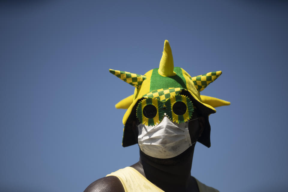A man wears a mask during a rally supporting Brazil's President Jair Bolsonaro on Copacabana beach, Rio de Janeiro, Brazil, Sunday, March 15, 2020. Thousands took to the streets on Sunday to demonstrate in favor of Bolsonaro, challenging in some states the ban on agglomerations due to coronavirus and ignoring his suggestion to postpone the acts. (AP Photo/Silvia Izquierdo)