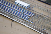 Bullet trains sit at their base as the surrounding land is still flooded following Typhoon Hagibis, in Nagano, central Japan Monday, Oct. 14, 2019. Rescue crews in Japan dug through mudslides and searched near swollen rivers Monday as they looked for those missing from the typhoon that caused serious damage in central and northern Japan. (Kyodo News via AP)