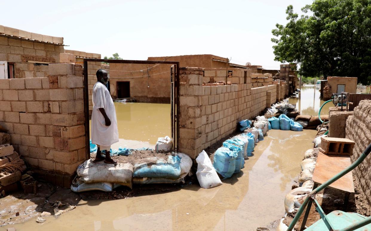 A man passes on the side of a flooded road in the town of Alkadro - AP Photo/Marwan Ali