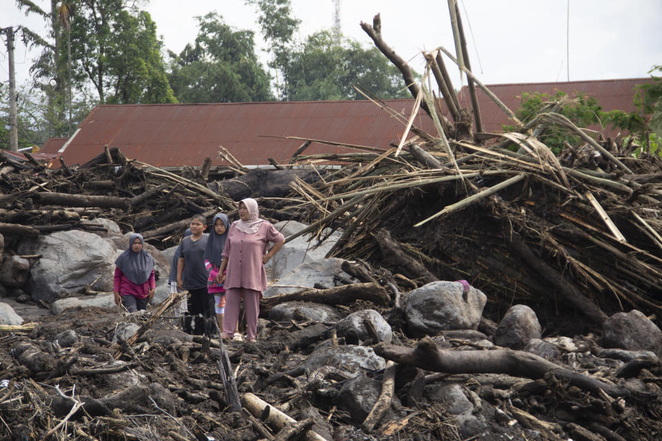 People inspect the damage by a flash flood in Agam, West Sumatra,Indonesia, Tuesday, May 14, 2024. Rescuers on Tuesday searched in rivers and the rubble of devastated villages for bodies, and whenever possible, survivors of flash floods that hit Indonesia's Sumatra Island over the weekend. (AP Photo/Sutan Malik Kayo)