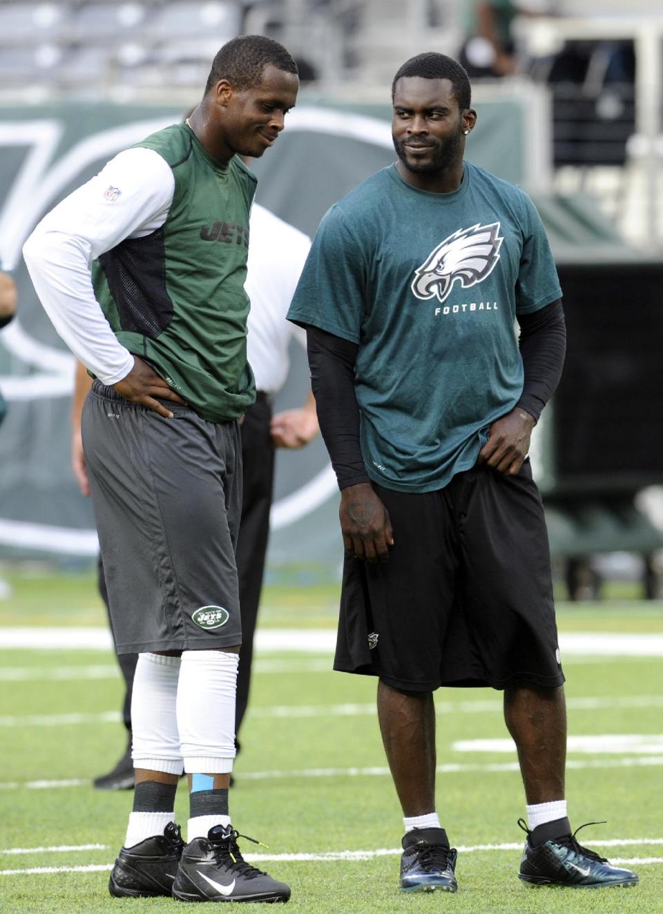 FILE - In this Aug. 29, 2013, file photo, New York Jets quarterback Geno Smith, left, talks to Philadelphia Eagles quarterback Michael Vick before a preseason NFL football game in East Rutherford, N.J. The Jets signed the former Philadelphia Eagles quarterback to a one-year deal Friday, March 21, 2014, and released Mark Sanchez, the one-time face of the franchise. (AP Photo/Bill Kostroun, File)