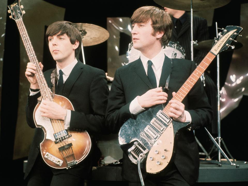 paul mccartney john lennon holding guitars onstage