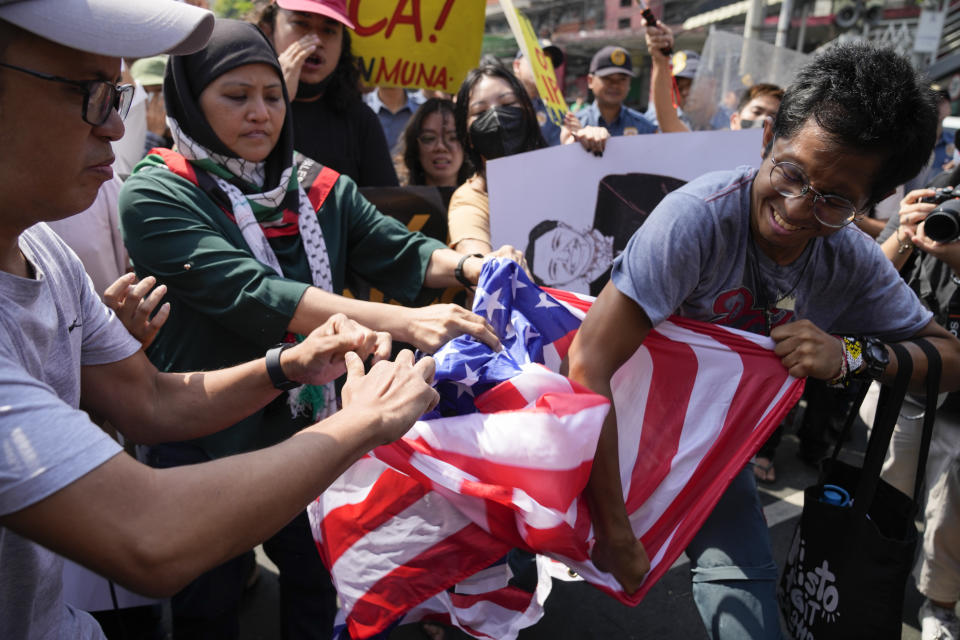 Protesters tear a U.S. flag during a rally near the Malacanang presidential palace in Manila, Philippines on Tuesday, March 19, 2024. The group is protesting against the visit of U.S. Secretary of State Antony Blinken. (AP Photo/Aaron Favila)